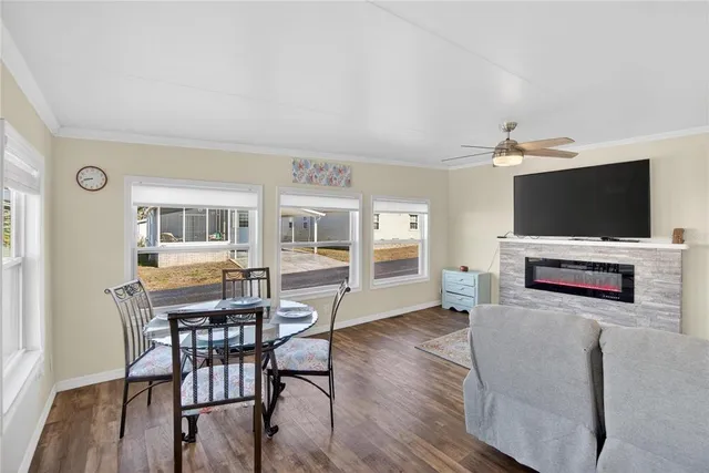 a living room with furniture wooden floor and a large window