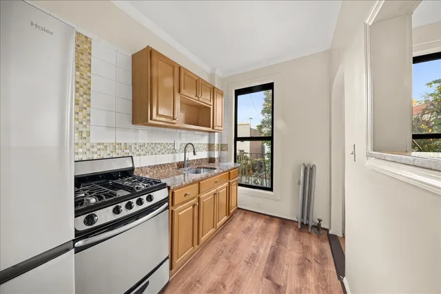 a view of empty room with wooden floor and window