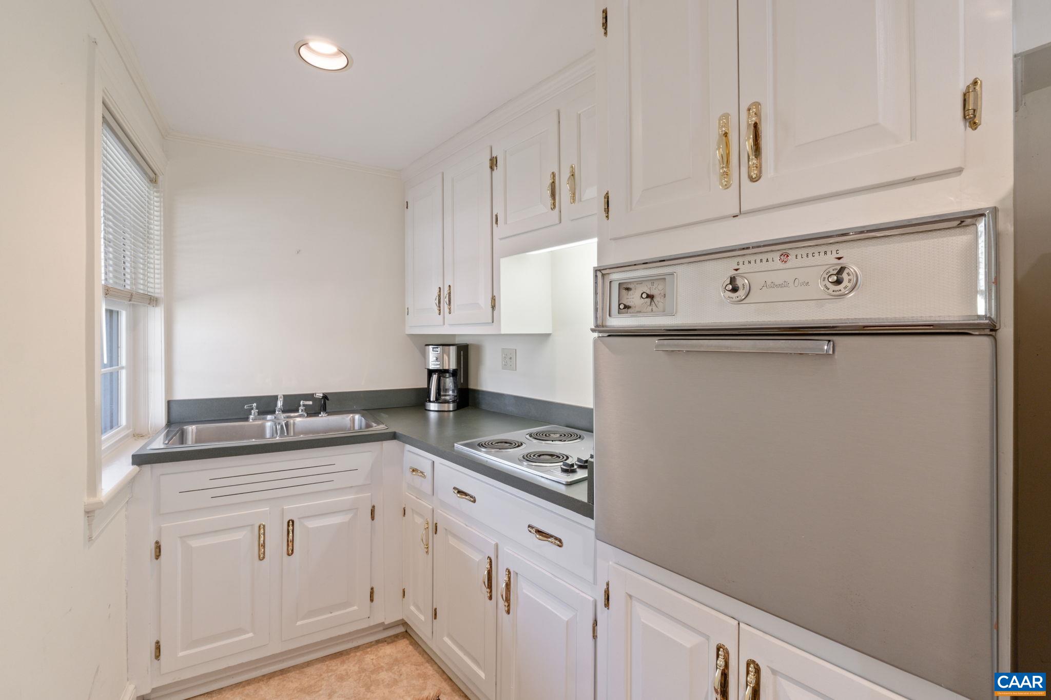 109 Camellia Drive Charlottesville, VA 22903 - Photo 29 of 49 a kitchen with granite countertop white cabinets and white appliances