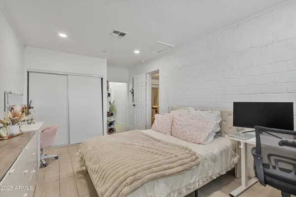 a bedroom with a bed tv and a window