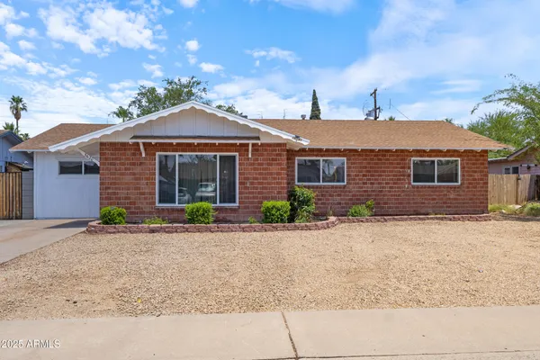 a front view of a house with a garden and yard