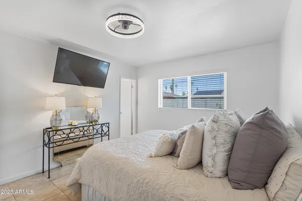 a bedroom with a bed and a flat screen tv