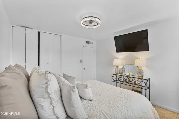 a bedroom with a bed and a flat screen tv