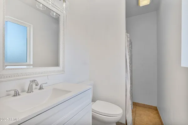 a bathroom with a sink toilet vanity and window