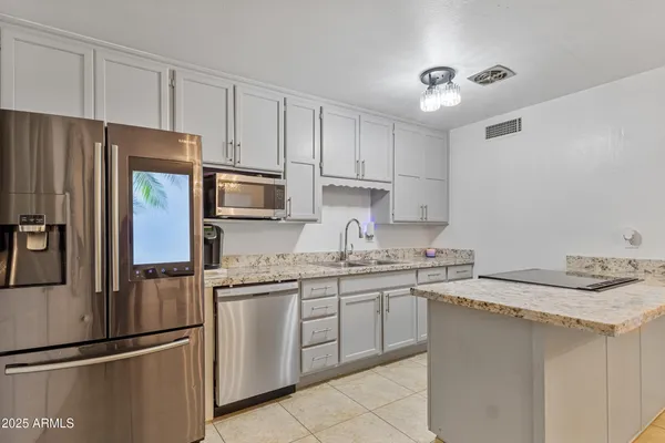 a kitchen with stainless steel appliances granite countertop a refrigerator sink and cabinets