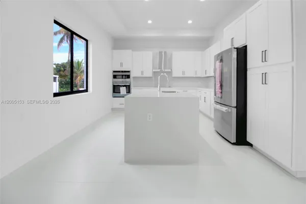 a kitchen with stainless steel appliances a refrigerator sink and microwave