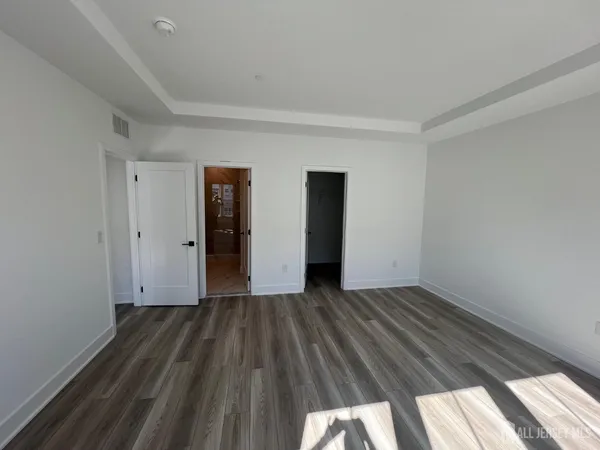 an empty room with wooden floor and closet