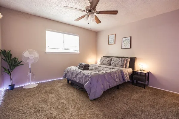 a spacious bedroom with a bed and a chandelier