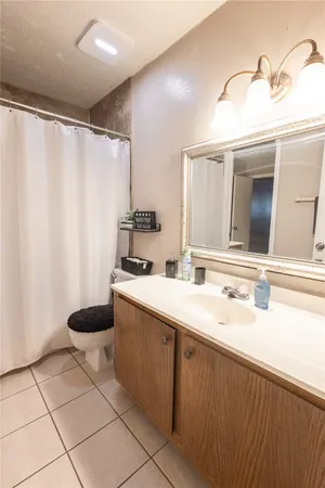 a bathroom with a granite countertop sink a toilet and a mirror