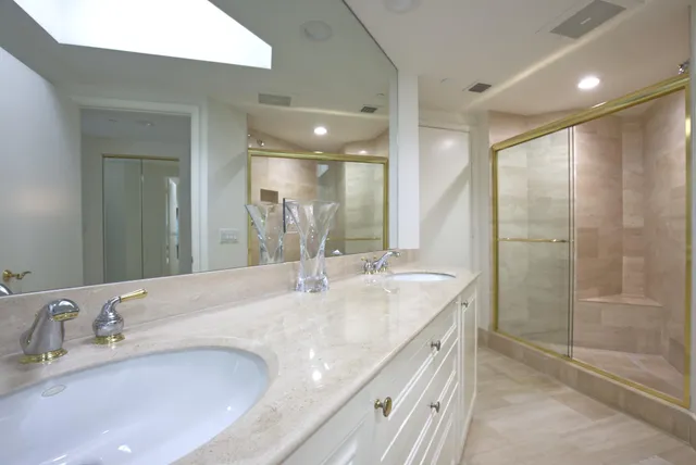 a bathroom with a granite countertop sink mirror and shower