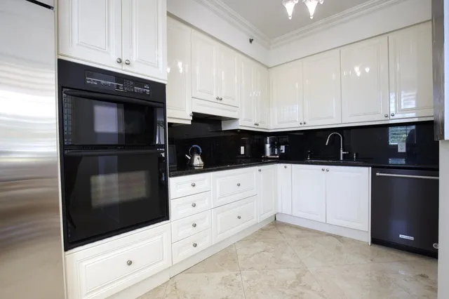 a kitchen with granite countertop white cabinets and stainless steel appliances
