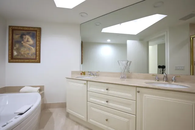 a bathroom with a granite countertop sink mirror and bathtub