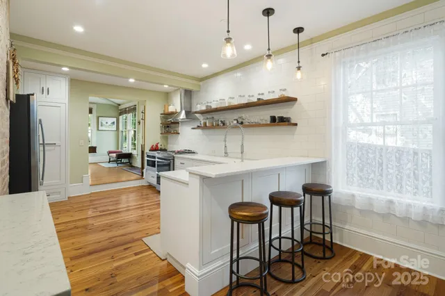 a open kitchen with white cabinets and stainless steel appliances