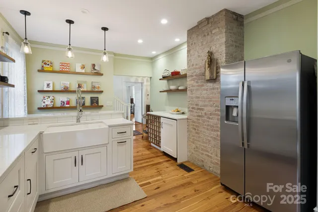 a kitchen with kitchen island a counter top space a sink refrigerator and cabinets