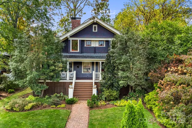 a front view of a house with a yard and trees