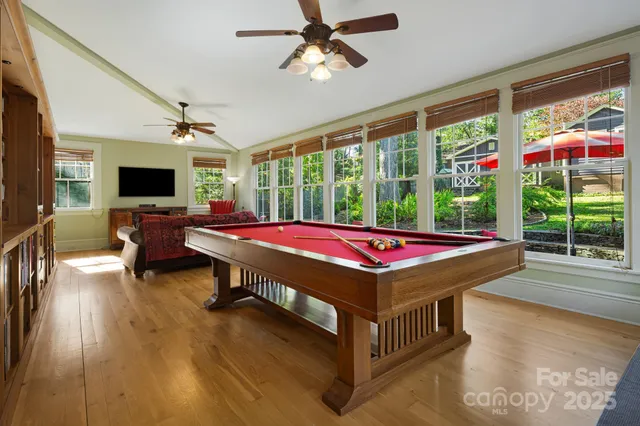 a room with pool table and windows