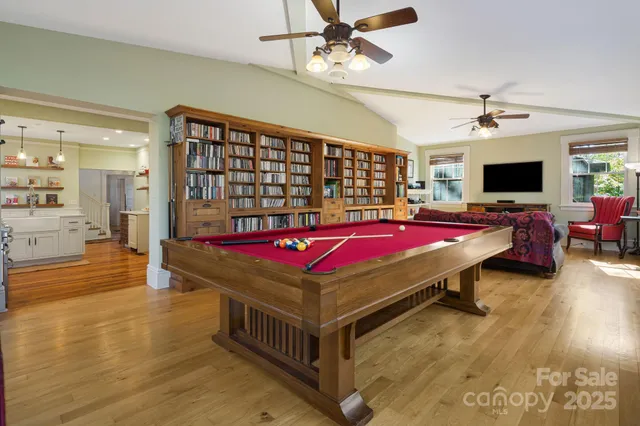 a room with pool table flat screen tv and windows