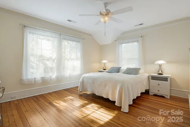 a bedroom with bed and wooden floor