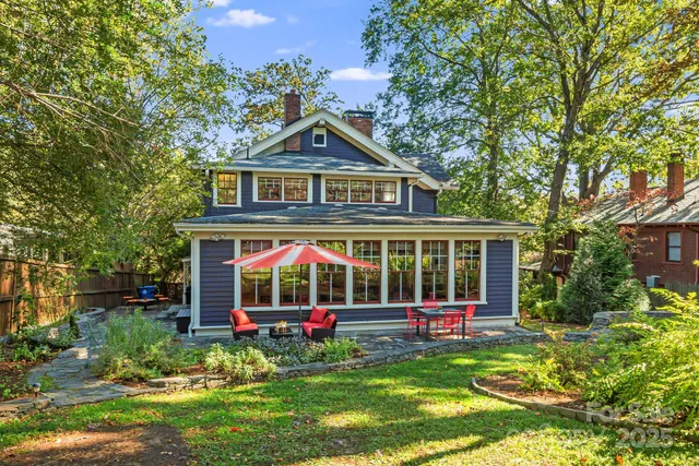 a view of a brick house with a yard and plants