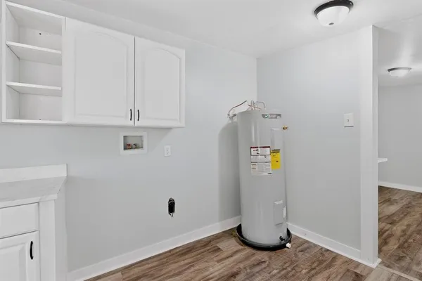 a view of a kitchen with refrigerator and wooden floor