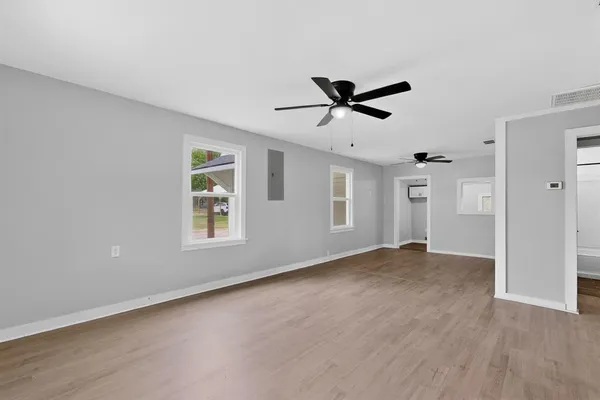 a view of a livingroom with a ceiling fan & wooden floor