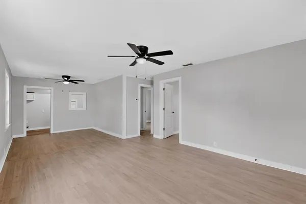 a view of a big room with wooden floor closet and windows