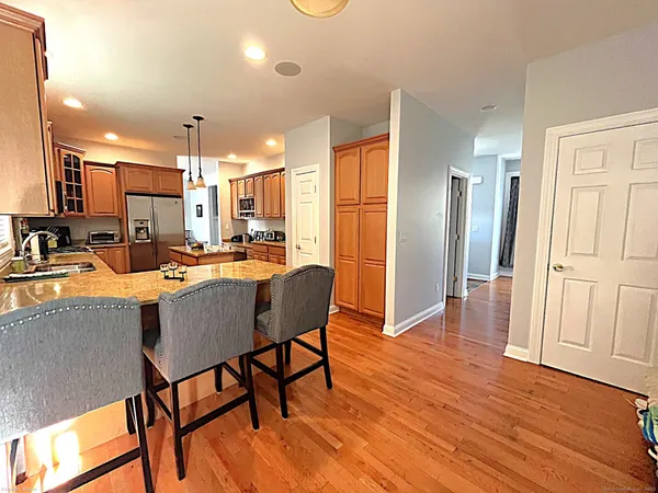 a dining hall with stainless steel appliances a dining table chairs and couches