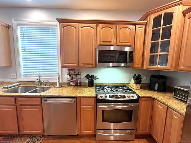 a kitchen with stainless steel appliances granite countertop a sink stove and cabinets