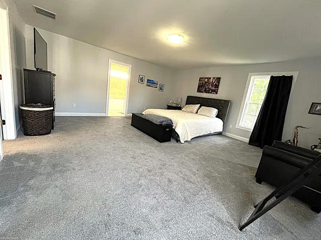 a bedroom with a bed flat screen tv and window