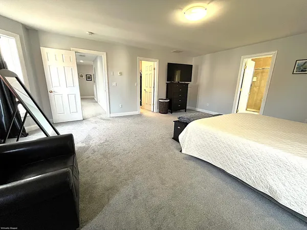 a spacious bedroom with a bed and a dresser