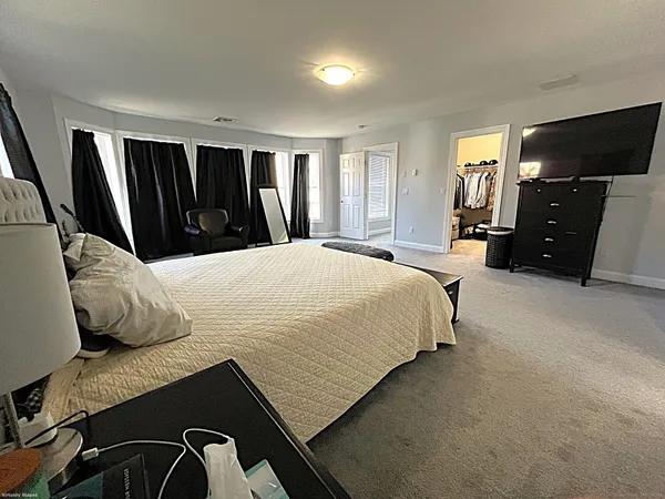 a bedroom with a bed closet and a flat tv screen