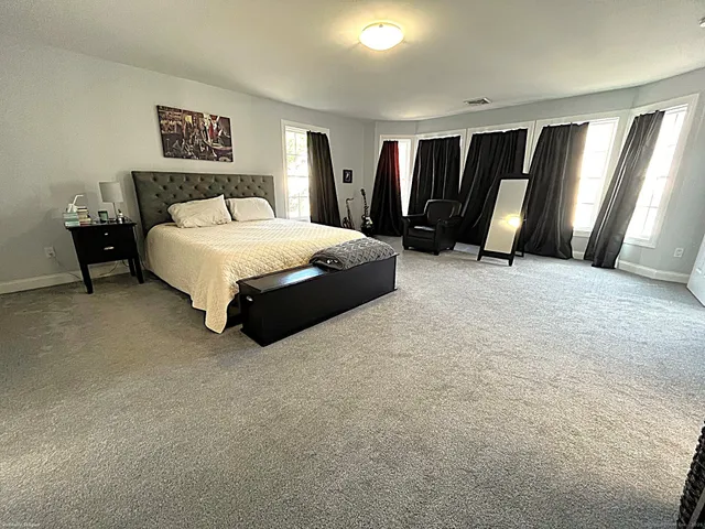 a spacious bedroom with a bed and cabinets