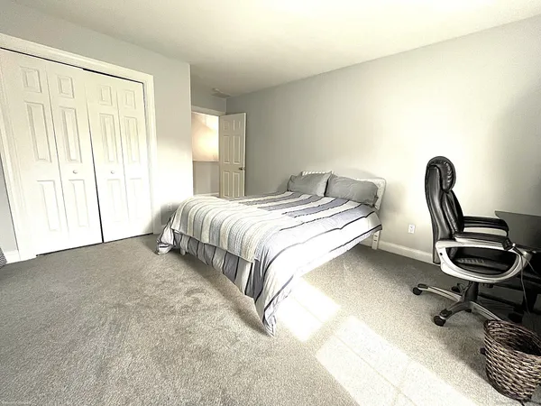 a bedroom with a bed and a chair