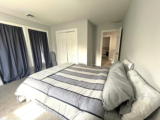 a bed sitting in a bedroom next to a window