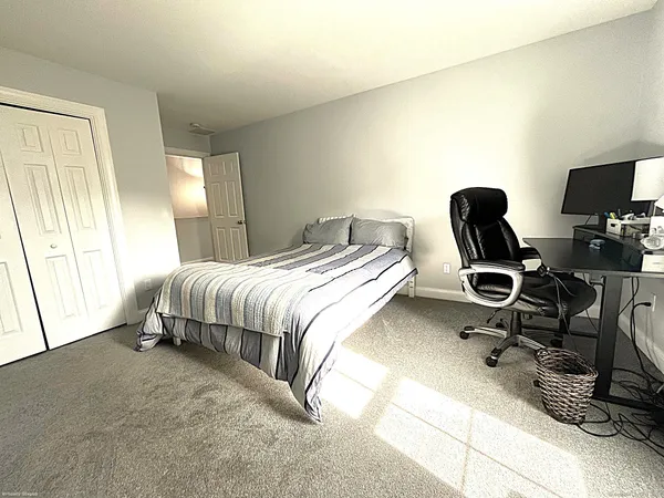 a bedroom with a bed a desk and chair