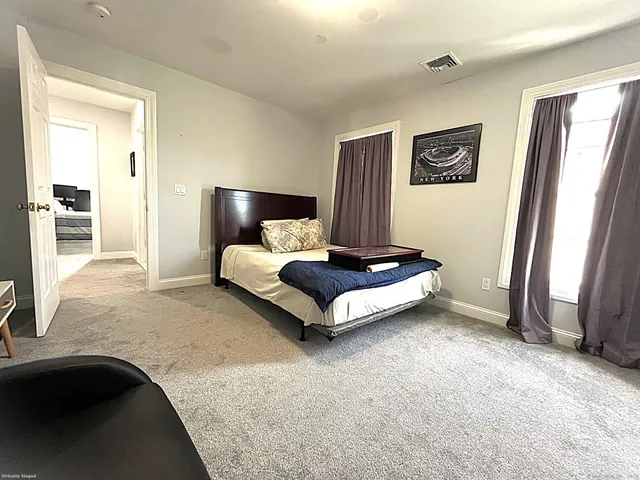 a living room with a bed furniture and a large mirror