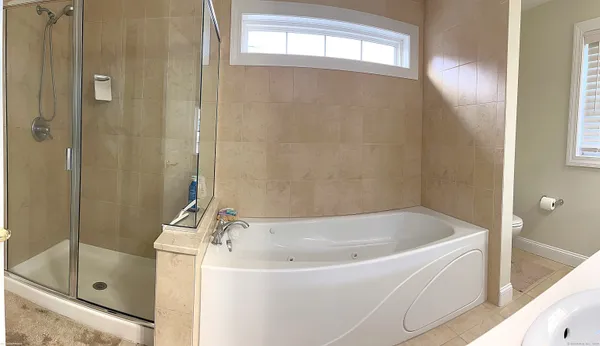 a white bath tub sitting next to a shower
