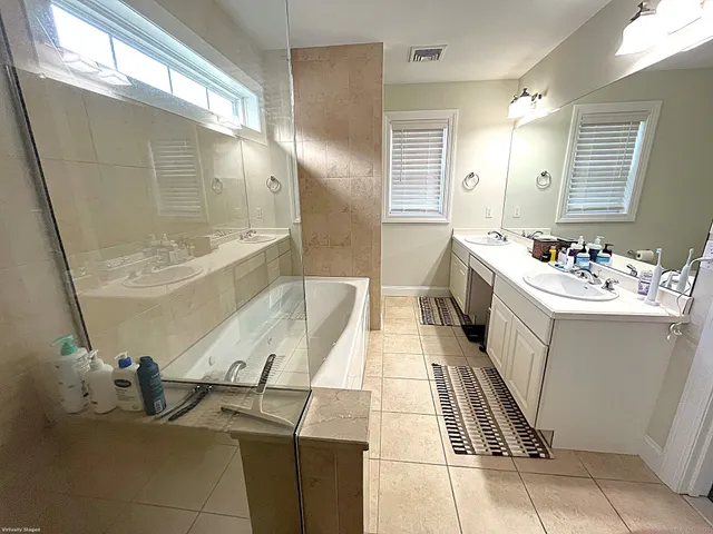 a bathroom with a sink mirror and a bathtub