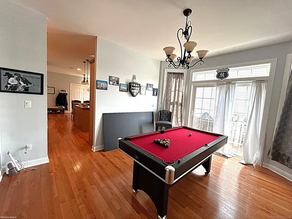a room with pool table and wooden floor