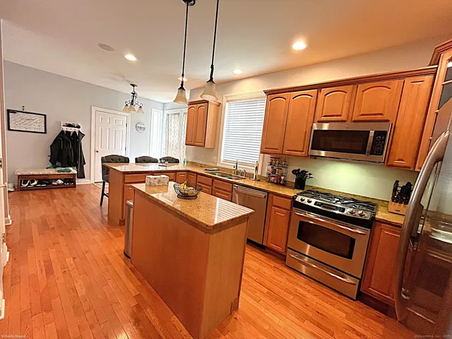 a kitchen with stainless steel appliances granite countertop a sink a stove and a refrigerator