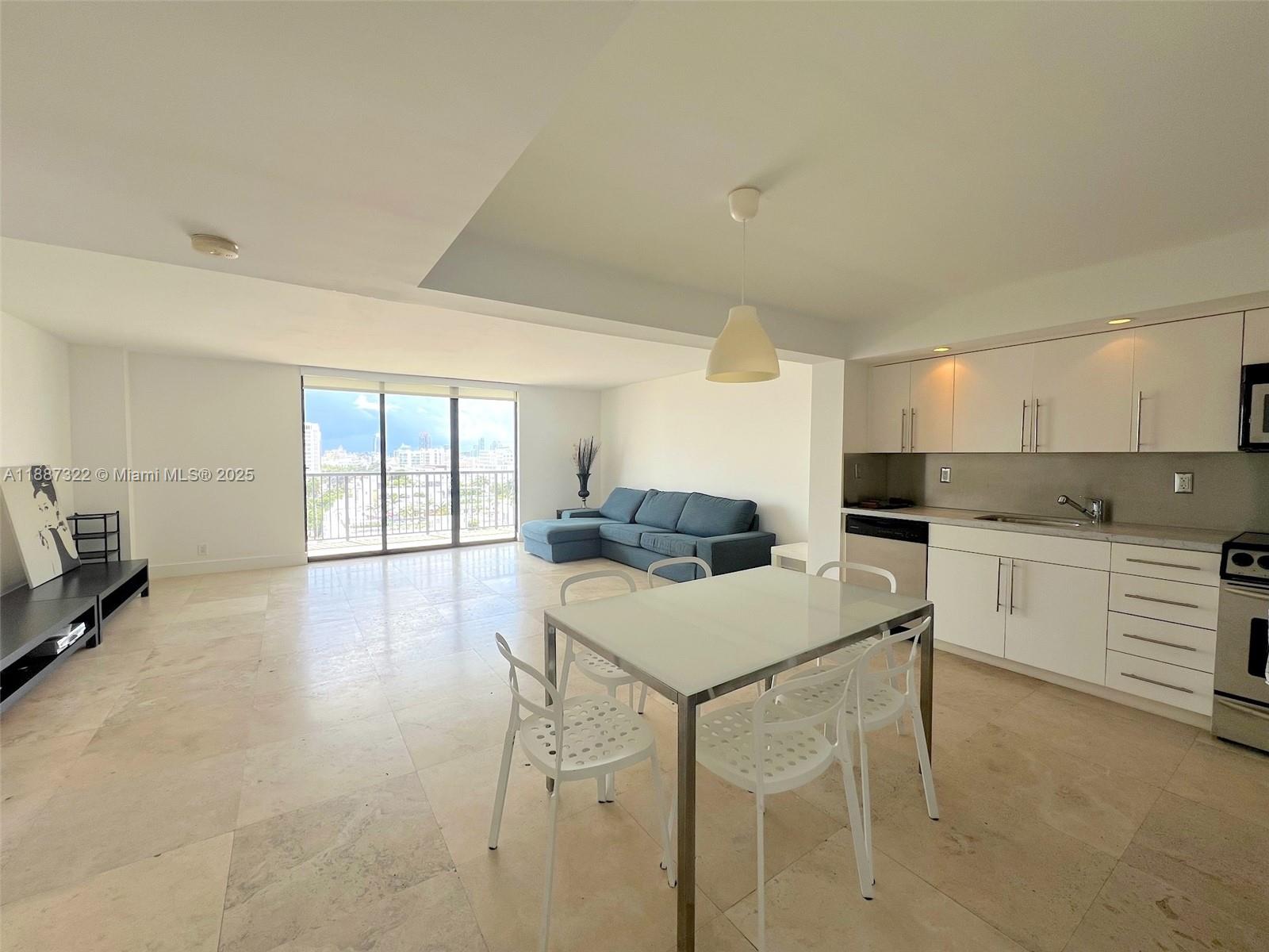 1800 Collins Avenue, Unit 12E Miami Beach, FL 33139 - Photo 1 of 17 a kitchen with a table chairs sink and cabinets