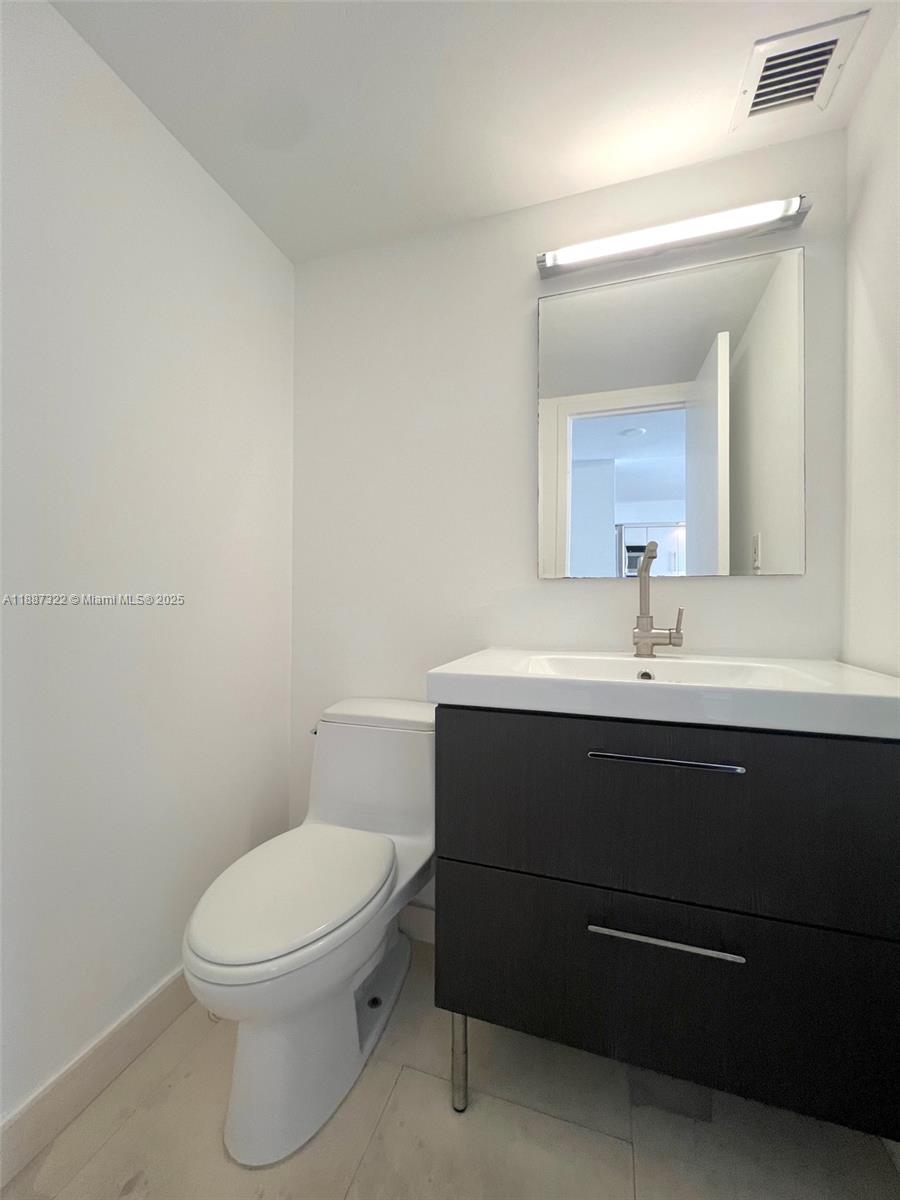 1800 Collins Avenue, Unit 12E Miami Beach, FL 33139 - Photo 11 of 17 a bathroom with a sink a toilet and mirror