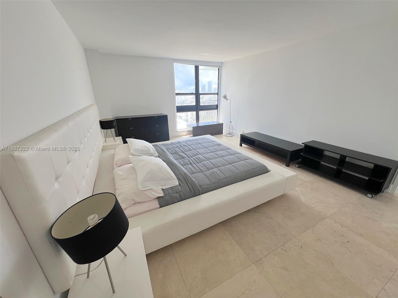 1800 Collins Avenue, Unit 12E Miami Beach, FL 33139 - Photo 14 of 17 a bedroom with a bed a window and dresser