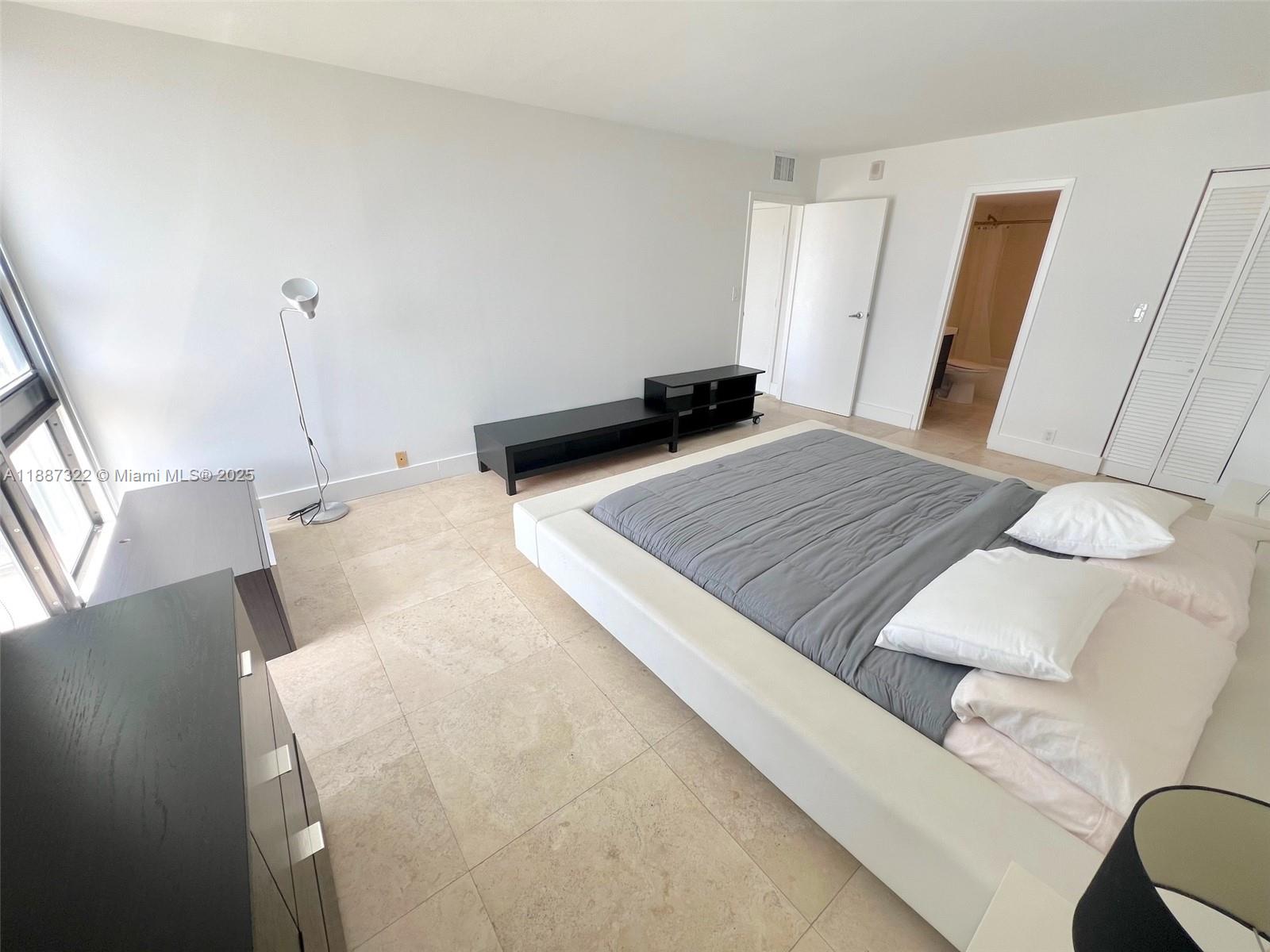 1800 Collins Avenue, Unit 12E Miami Beach, FL 33139 - Photo 15 of 17 a bedroom with a bed and wooden floor