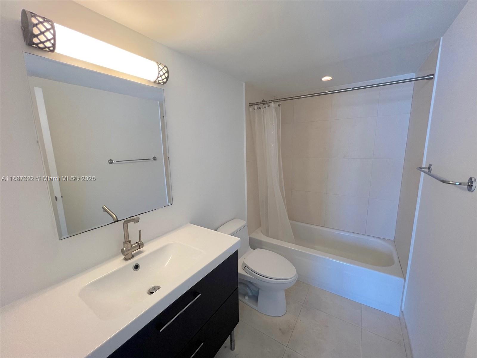 1800 Collins Avenue, Unit 12E Miami Beach, FL 33139 - Photo 16 of 17 a bathroom with a sink mirror toilet and bathtub