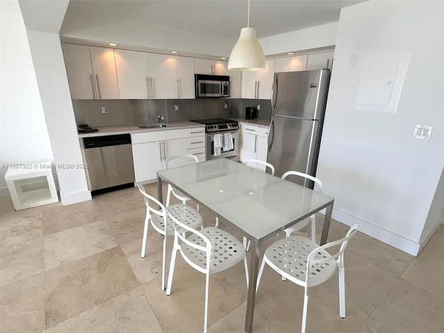 a kitchen with stainless steel appliances a microwave a stove a sink a microwave and a refrigerator