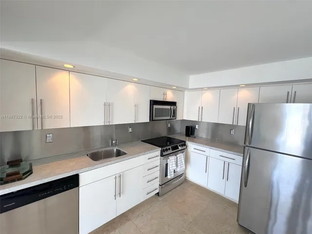 a kitchen with stainless steel appliances a refrigerator sink and microwave