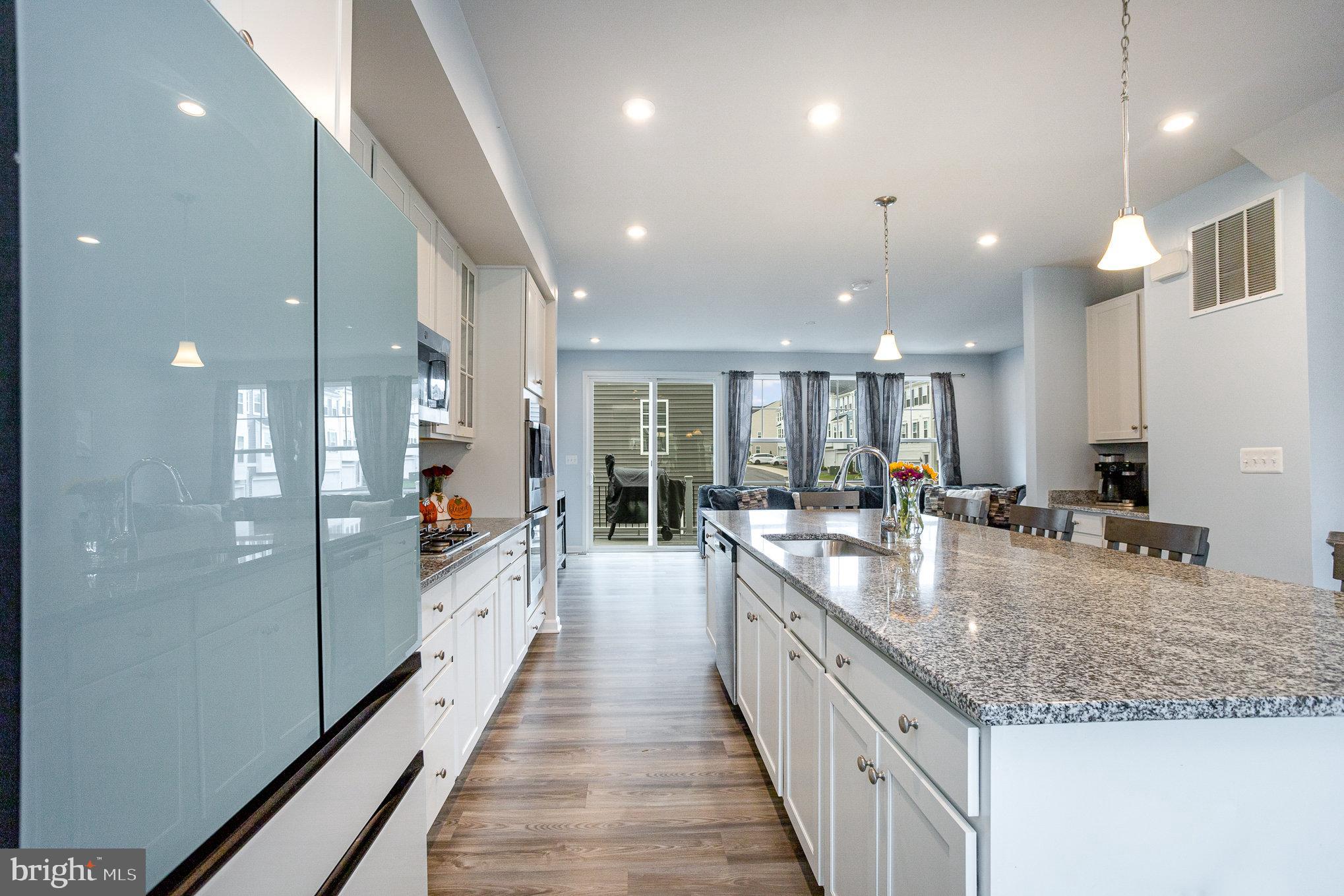 18236 Summit Pointe Drive Triangle, VA 22172 - Photo 16 of 36 a large white kitchen with kitchen island a large island a sink stainless steel appliances and cabinets