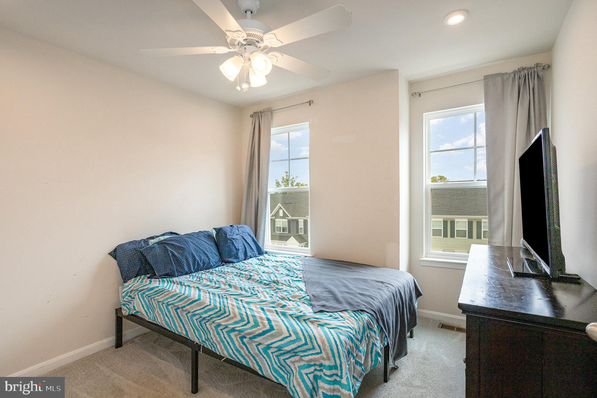 18236 Summit Pointe Drive Triangle, VA 22172 - Photo 27 of 36 a bedroom with a large bed and a flat tv screen on a dresser