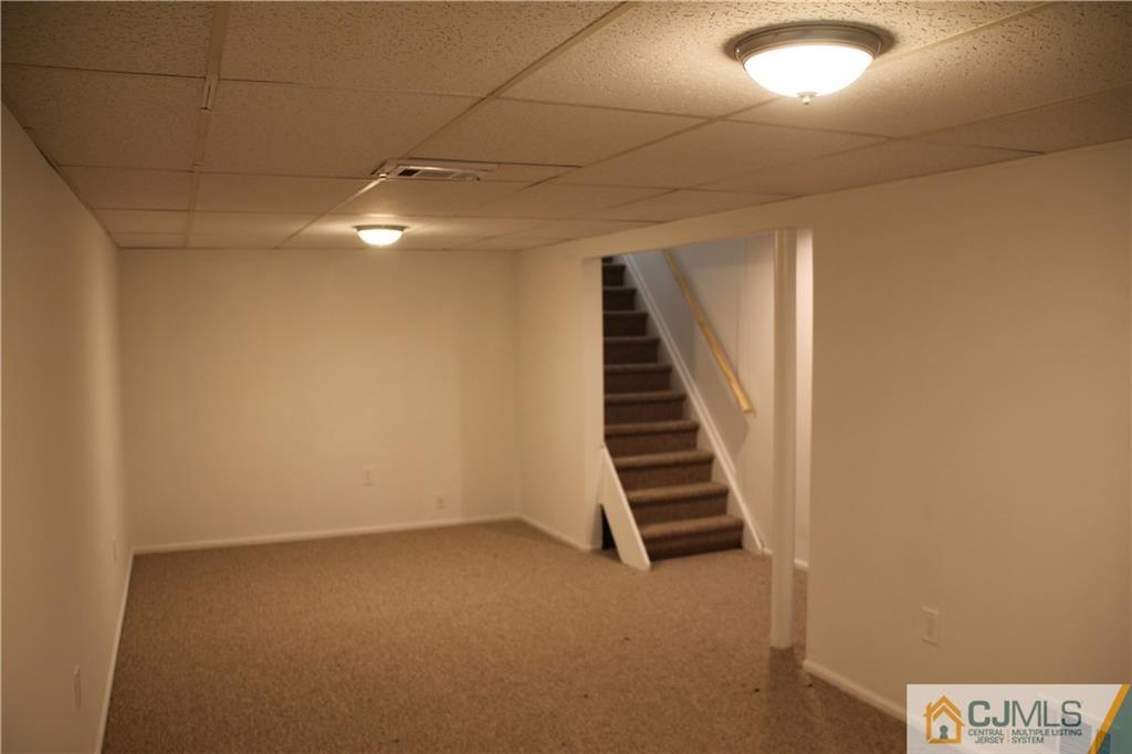 21 Channing Road East Brunswick, NJ 08816 - Photo 18 of 25 an empty room with windows and stairs